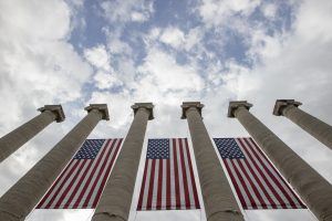 A photo of American flags hanging from the Columns.