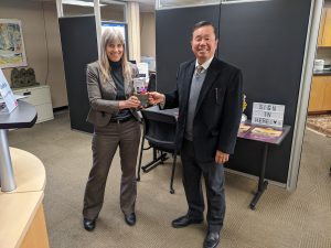 A photo of Catherine Rymph, interim director, presenting President Choi with Honors College swag.