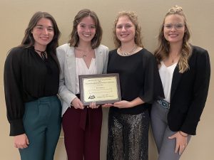 A photo of Aliyah Luntsford, Catriona Chew, Caleigh Grote and Alexia Sweiger holding an award for winning the academic quadrathlon.