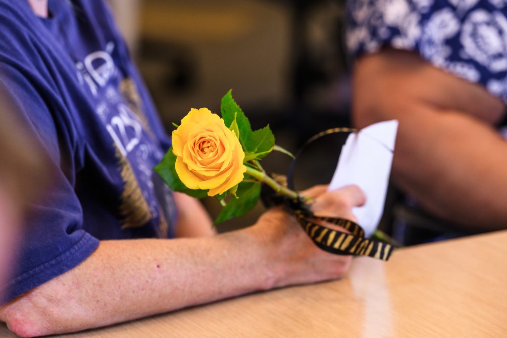 Donor family member holding a yellow rose.