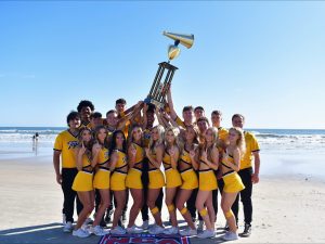 Mizzou Cheer holding up their trophy on the beach.