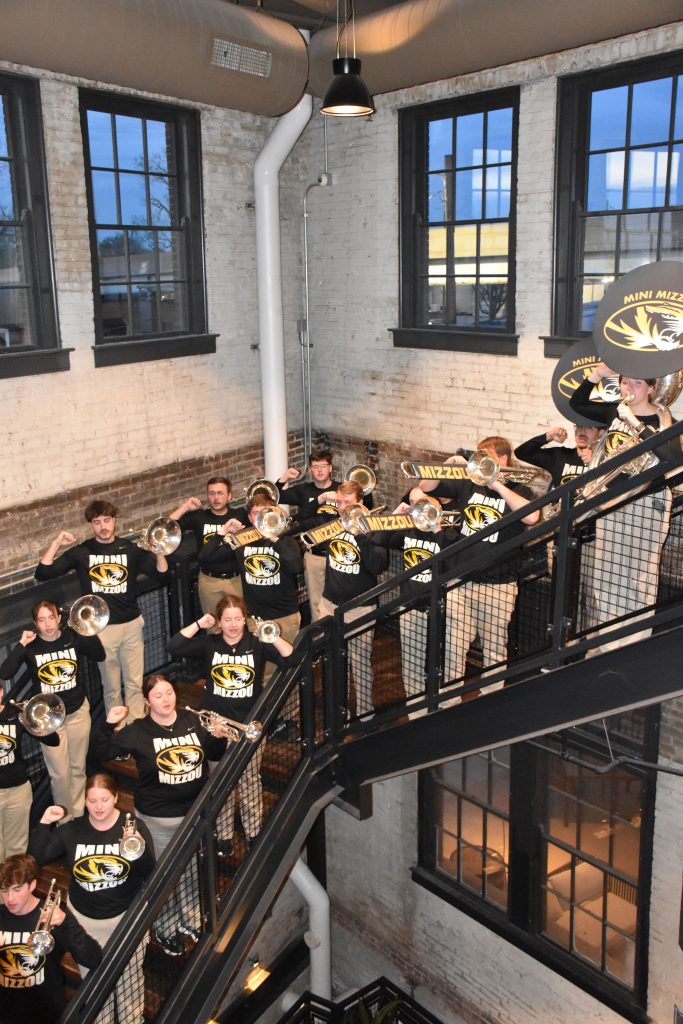 Mini Mizzou performing on a staircase.