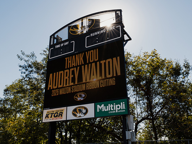 A Mizzou scoreboard displays the words "Thank You Audrey Walton - 2026 Walton Stadium Ribbon Cutting" on a sunny day